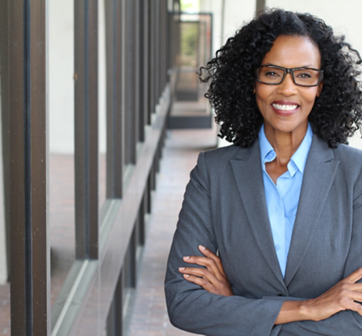 Businesswoman with glasses smiling with arms folded