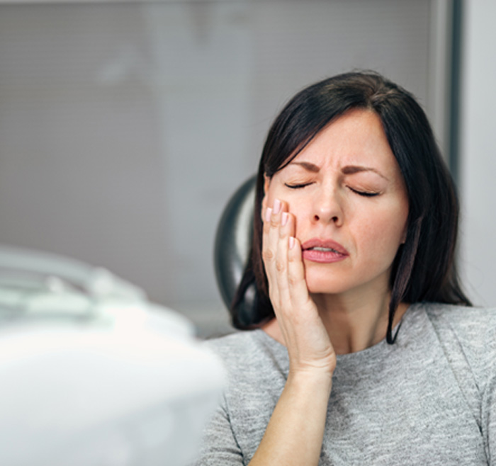 Patient with toothache sitting in treatment chair