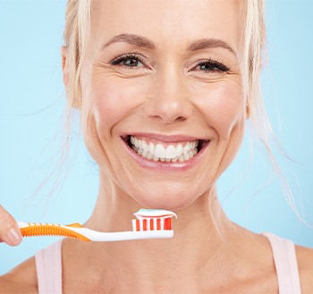 Smiling middle-aged woman holding toothbrush